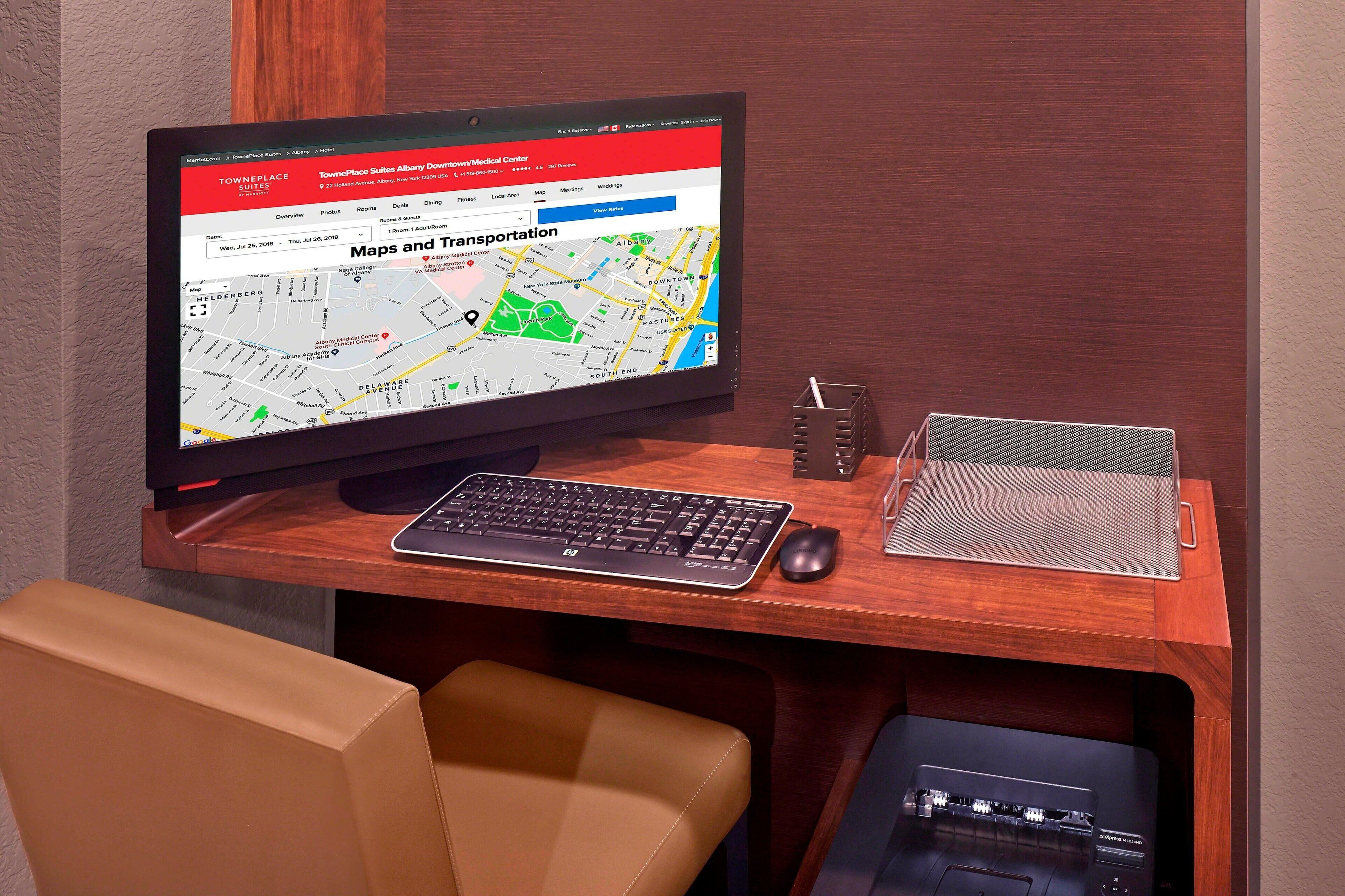 A computer monitor displaying a map, a keyboard, a mouse, and a desk organizer.
