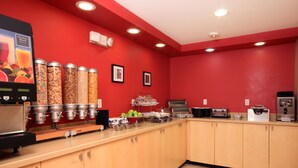 A breakfast bar with a juice dispenser, cereal dispensers, and a toaster.