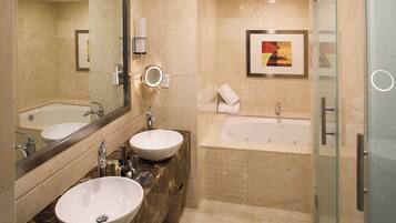 Un baño moderno con dos lavamanos, una bañera y una cabina de ducha de vidrio.