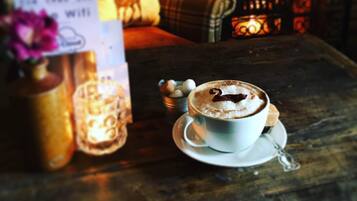 Un espace intérieur chaleureux, avec une tasse de café, une bougie et un panneau indiquant la présence d’une connexion Wi-Fi.