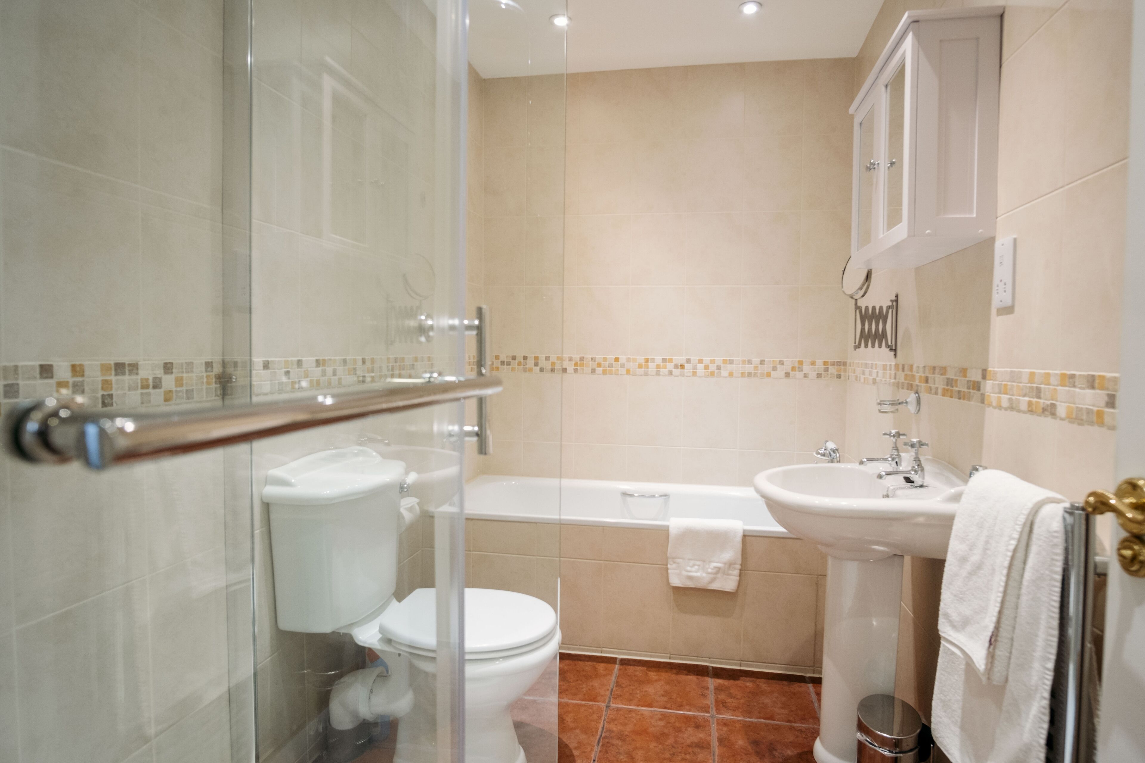 A bathroom with a toilet, bathtub, and sink.
