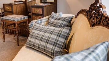 Un dormitorio con una cama, una silla de madera y una mesita de noche.