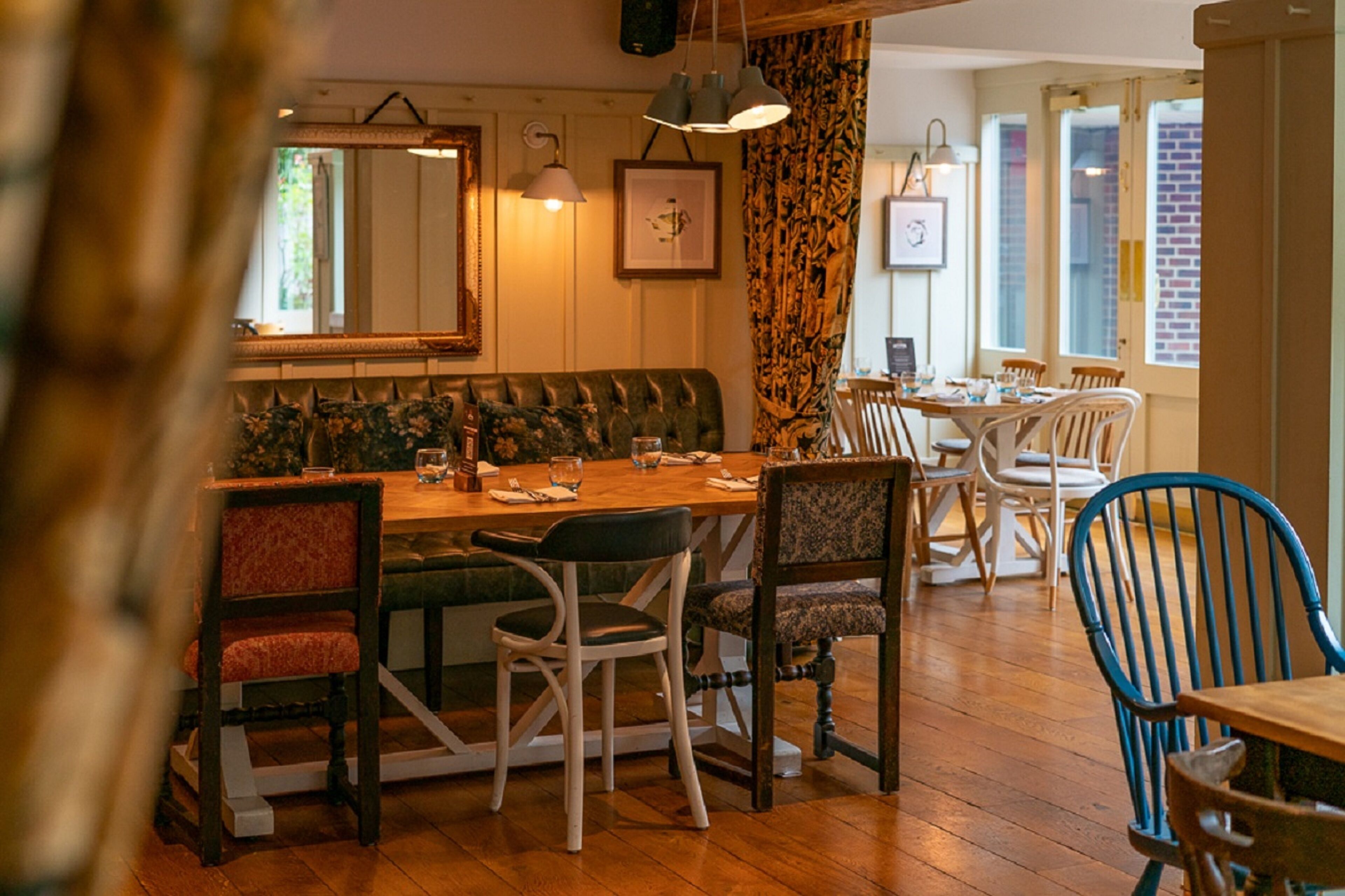 A cozy dining area with a wooden table, chairs, and a cushioned bench.