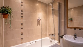 A modern bathroom with a bathtub, a shower, and a sink.
