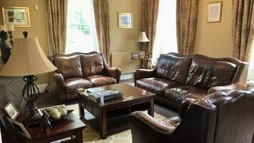 Ein Wohnzimmer mit Ledersofas, einem Couchtisch und einer Lampe.