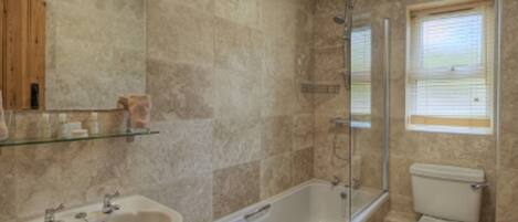 A bathroom with a bathtub, sink, and toilet, all in a neutral color scheme.