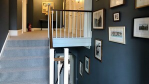 A staircase with striped carpet leading to a landing with a white railing. - Chatton Park House Hotel Adult Only (Alnwick)
