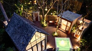 A cozy outdoor area with a hot tub, wooden deck, and a glass-enclosed building. - Proud Phu Fah Maerim (Mae Rim)