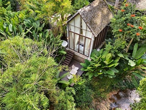 A small, rustic house surrounded by lush greenery and a small stream. - Proud Phu Fah Maerim (Mae Rim)