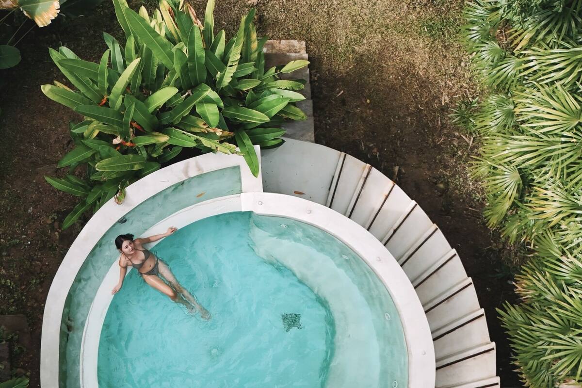 Vista aérea de una piscina rodeada de exuberante vegetación.