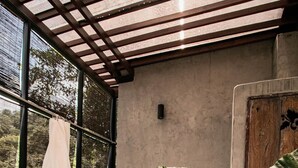 A bathroom with a large bathtub, a shower, and a window overlooking greenery. - Proud Phu Fah Maerim (Mae Rim)