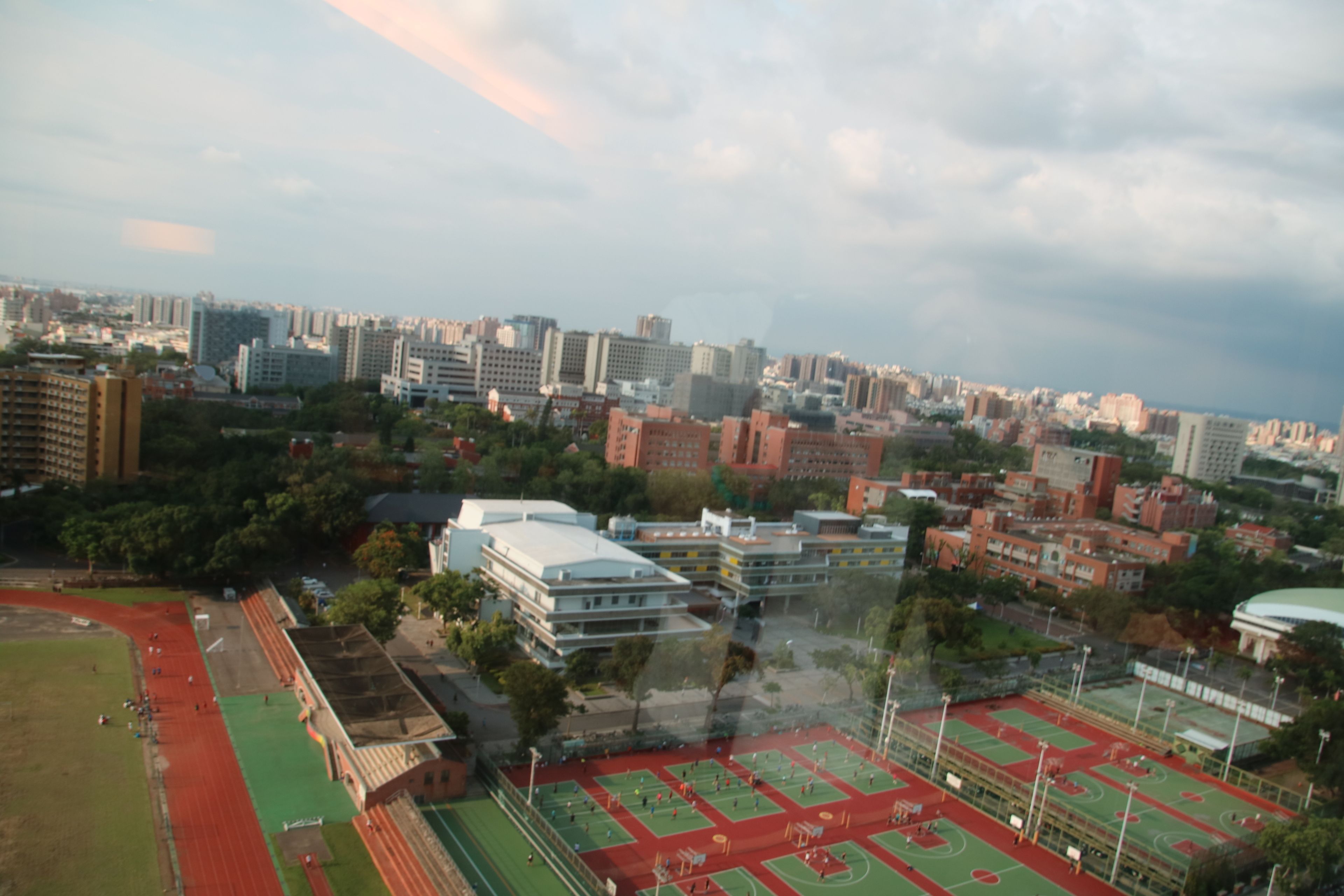 Vista aérea de un paisaje urbano con un gran complejo deportivo que cuenta con varias canchas y edificios.