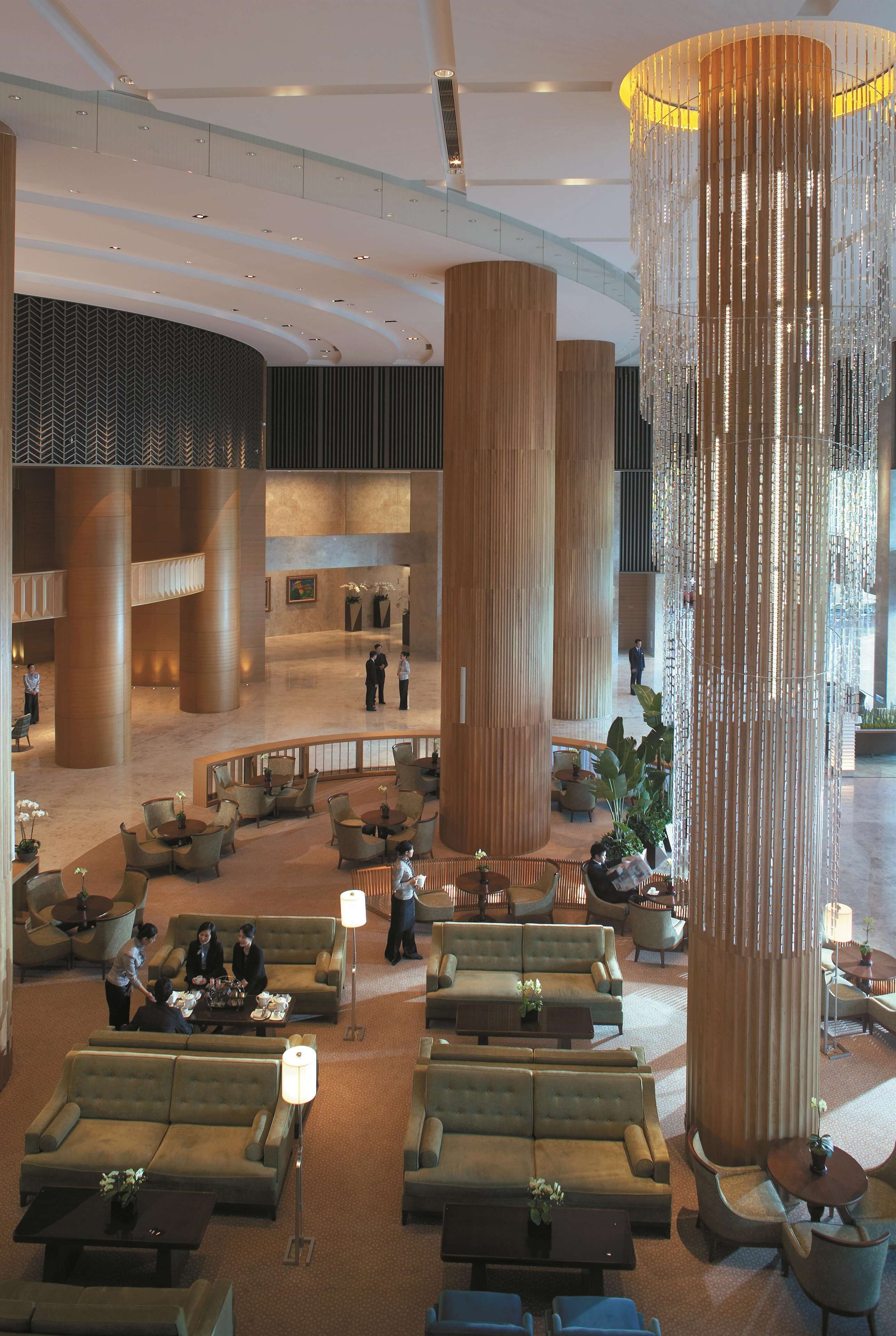 A spacious lobby with high ceilings, large cylindrical columns, and multiple seating areas.
