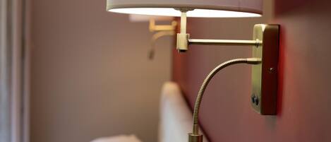 A wall-mounted lamp with a flexible neck and a pull chain.