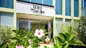 A hotel with a sign reading "Hotel les Jardins."