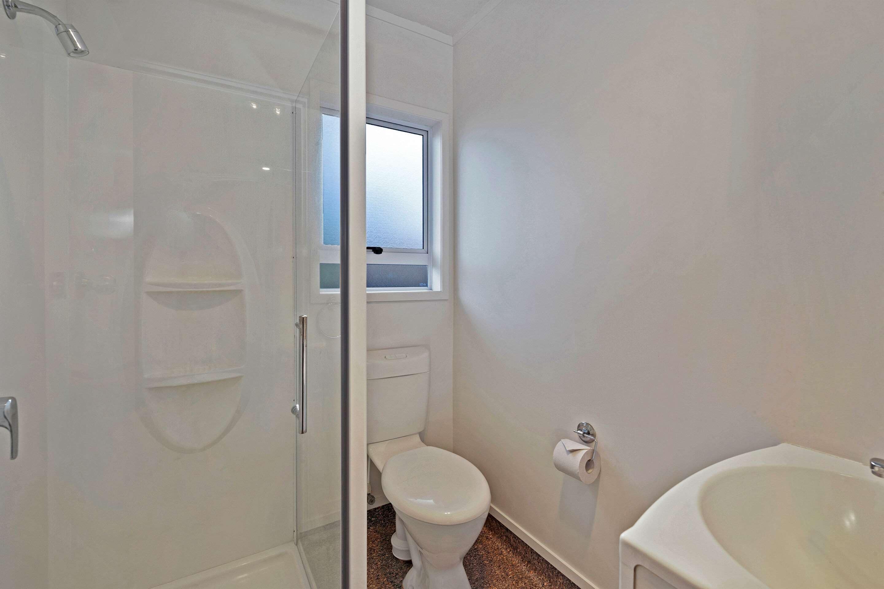 A bathroom with a shower, toilet, and sink.