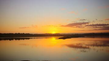 Un lago tranquilo al atardecer bajo un cielo despejado.