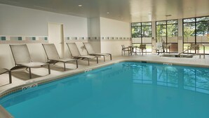 Una piscina con sillas de descanso y una puerta.