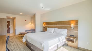 A hotel room with a large bed, bedside tables, a desk, and a chair.