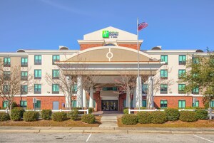 A Holiday Inn Express hotel with a central entrance, a brick facade, and a flagpole.