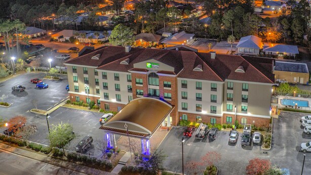 A hotel with a parking lot, multiple floors, and a swimming pool. - Holiday Inn Express & Suites Gulf Shores by IHG (Gulf Shores)