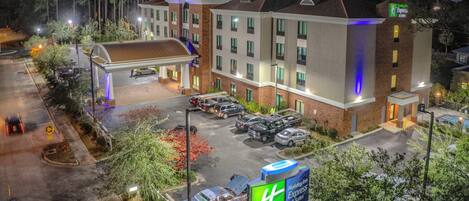 Un hotel Holiday Inn Express con parcheggio, una galleria coperta e una piscina.