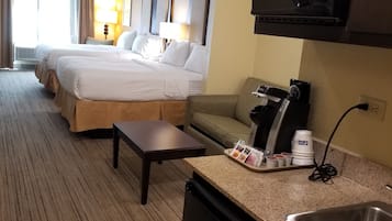 Habitación de hotel con dos camas, un kitchenette, un microondas y una cafetera.