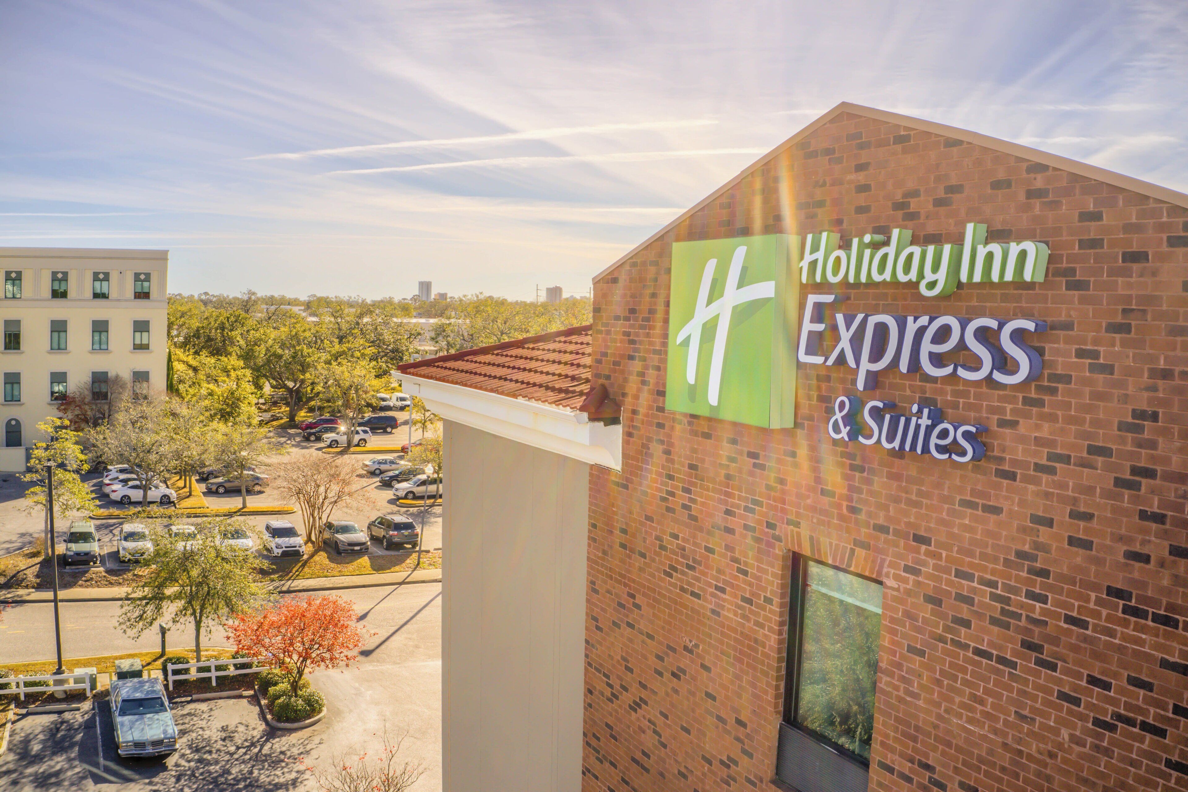 Edificio de Holiday Inn Express & Suites con un estacionamiento al frente.