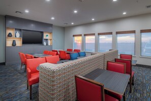 Une salle de conférence équipée d’un grand écran, de plusieurs tables et de chaises.