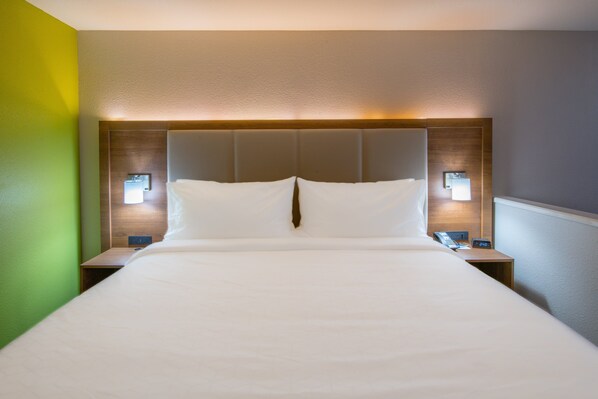 A hotel room with a large bed, two bedside tables, and wall-mounted lamps. - Holiday Inn Express & Suites N Waco Area - West by IHG (West)