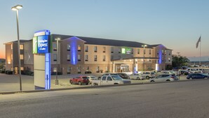 Un hôtel Holiday Inn Express & Suites doté d’un parking et d’une entrée bien éclairée.