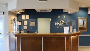 A reception desk with a sign reading "MICROTEL INN & SUITES BY WYNDHAM". - Microtel Inn & Suites by Wyndham Columbus/Near Fort Benning (Columbus)