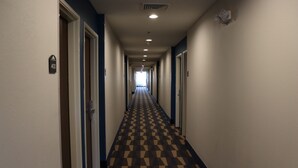 A hotel hallway with a checkered floor pattern, doors on both sides, and a sign indicating room number 403. - Microtel Inn & Suites by Wyndham Columbus/Near Fort Benning (Columbus)