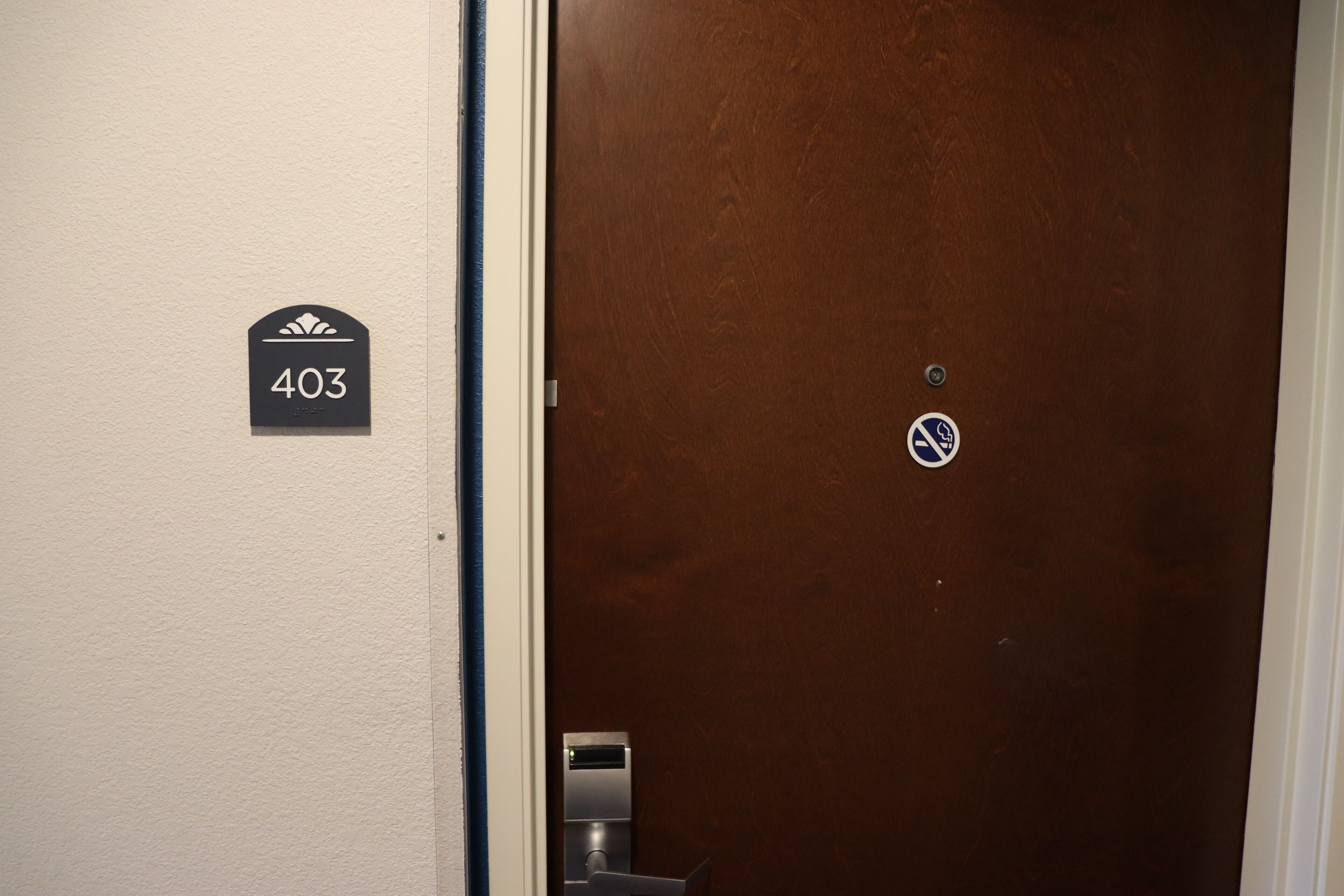 A door with a number sign '403' and a no-smoking sign.