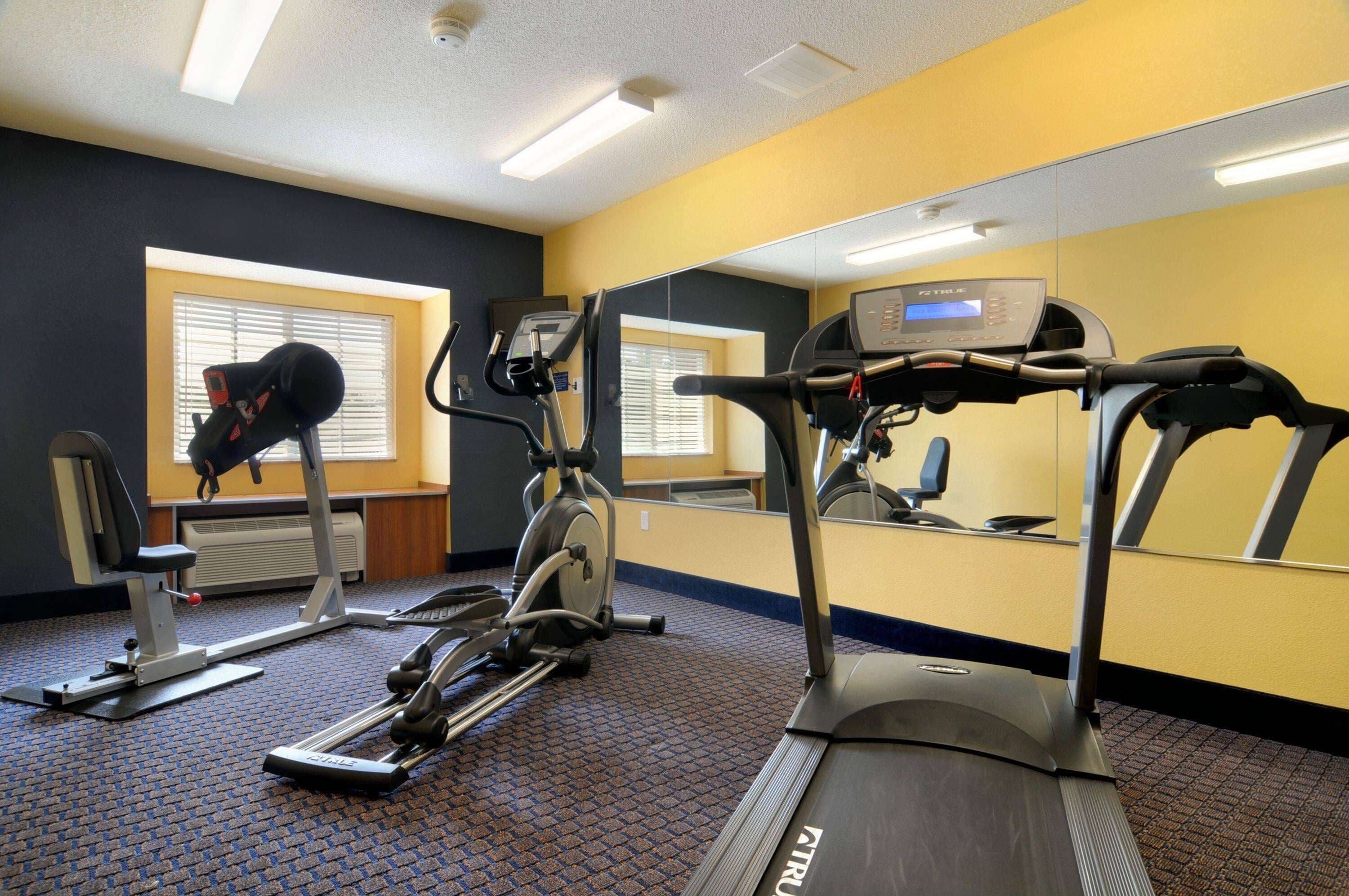 A gym with treadmills, stationary bikes, and weight machines.