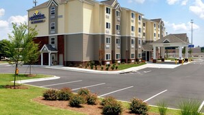 A Microtel by Wyndham hotel with a parking lot and landscaped areas. - Microtel Inn & Suites by Wyndham Columbus/Near Fort Benning (Columbus)