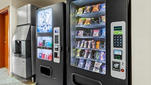 Two vending machines with drink and snack options, a water dispenser, and a digital display.