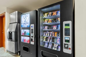 Two vending machines with drink and snack options, a water dispenser, and a digital display.