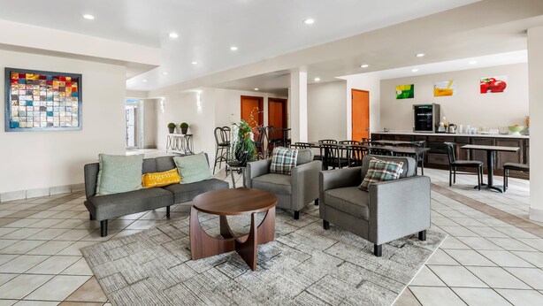 A spacious living area with a sofa set, a coffee table, and a dining area with chairs and a table.