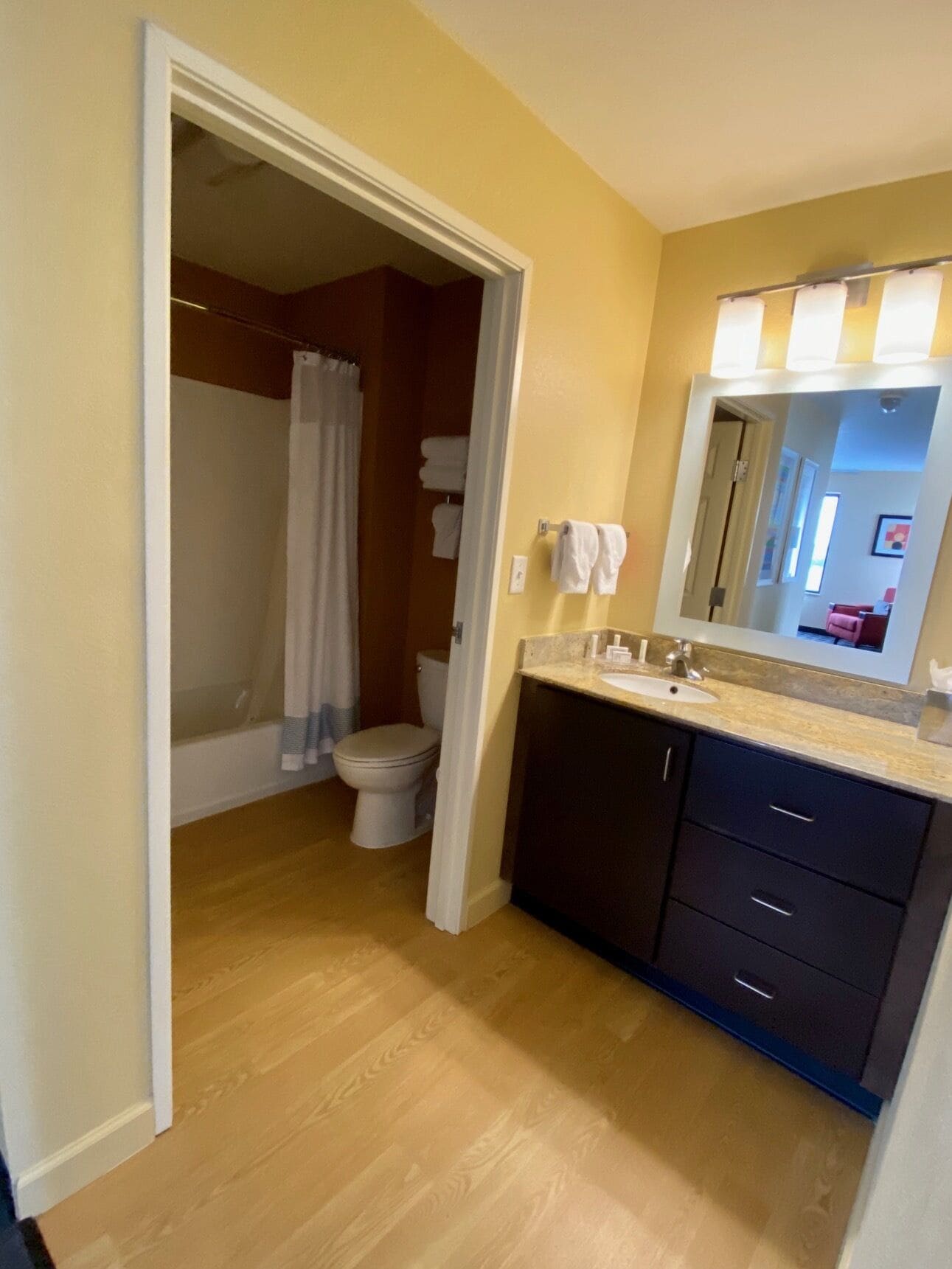 A bathroom with a shower, toilet, and sink.