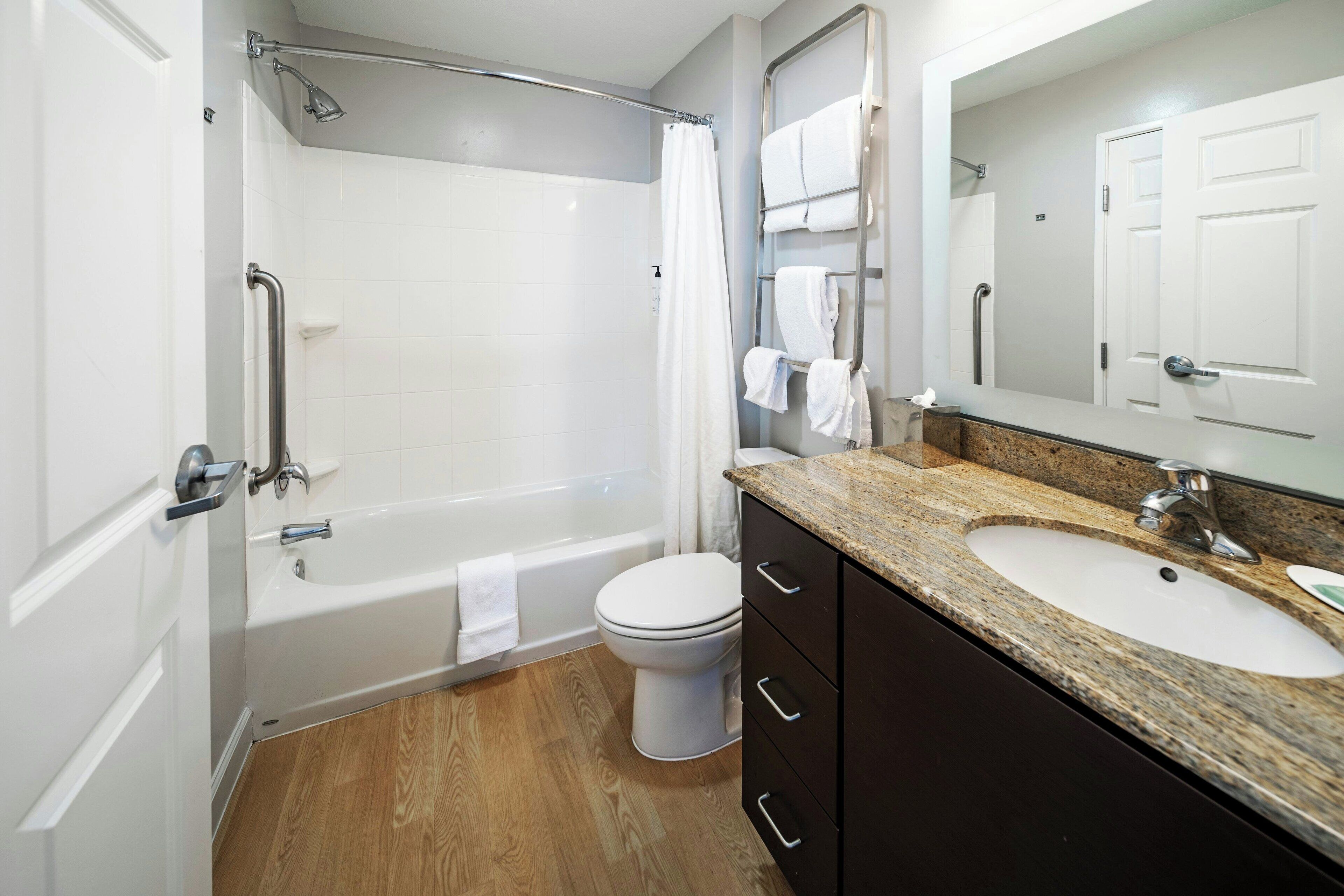 A modern bathroom with a bathtub, toilet, and sink.