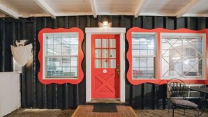 A red door with a white cross on it, flanked by two windows with decorative frames. - Arrowhead Tree Top Lodge (Lake Arrowhead)