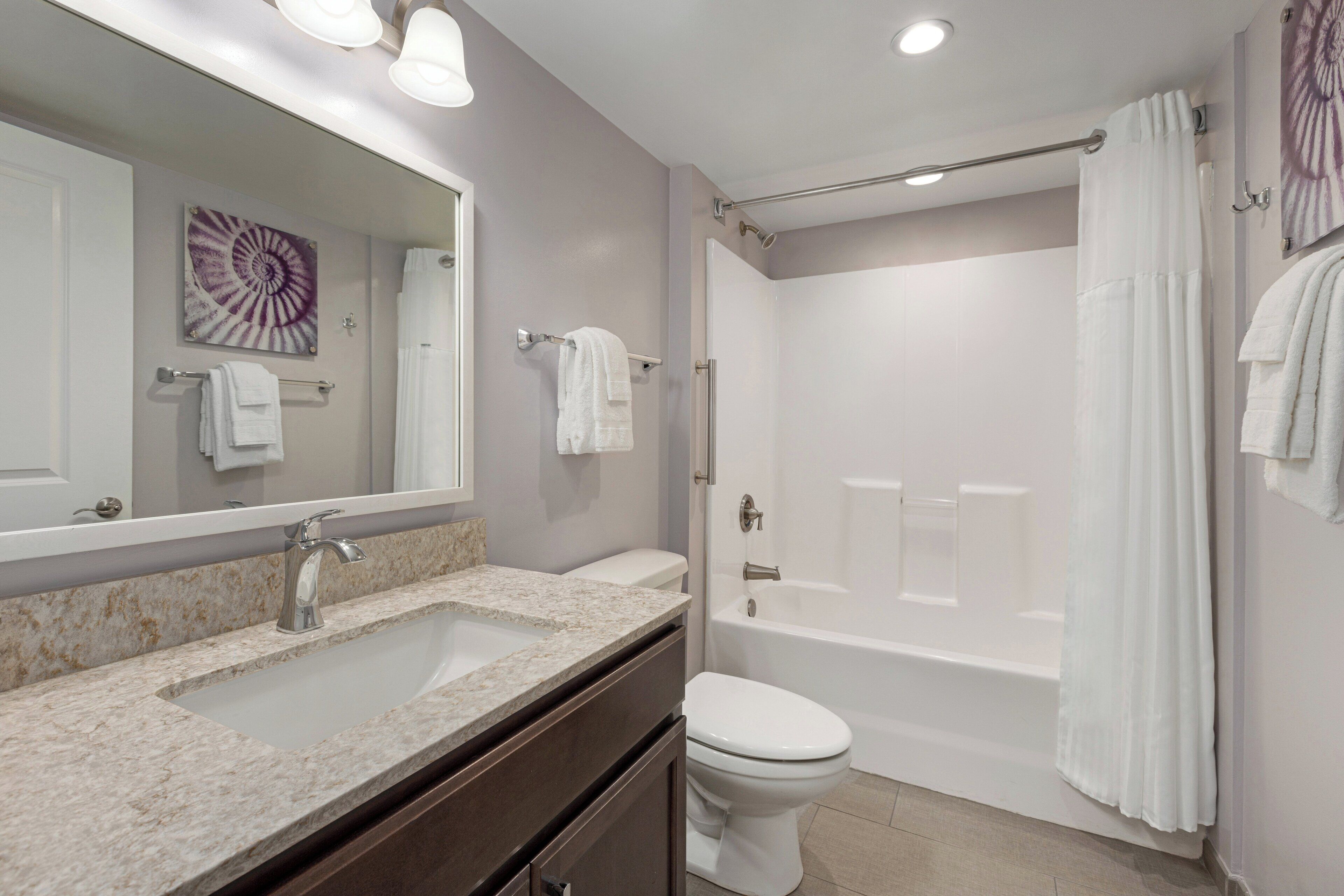 A bathroom with a sink, toilet, and bathtub.