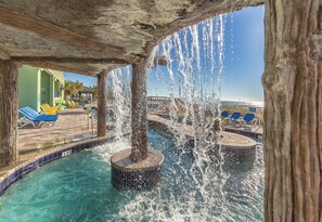 A pool area with water jets, lounge chairs, and a view of the beach. - Club Wyndham Towers on the Grove (North Myrtle Beach)
