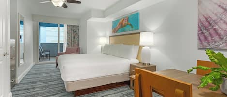 A hotel room with a bed, bedside table, lamp, and a dining table with chairs.