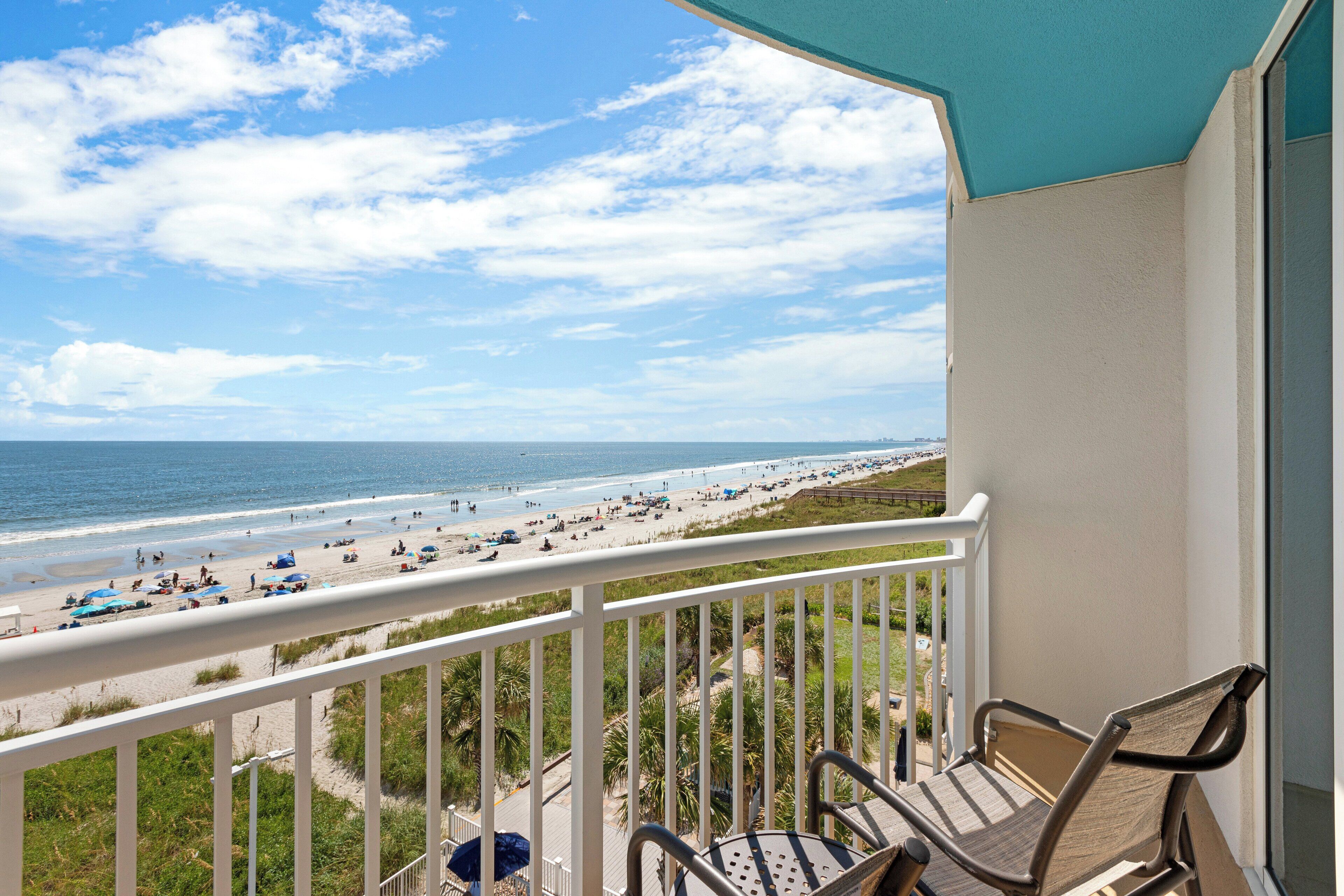 Ein Balkon mit Blick auf Strand und Meer.