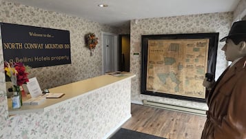 Una recepción con un cartel de bienvenida para el North Conway Mountain Inn, una propiedad de Bellini Hotels.