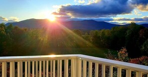 A deck with a view of a mountainous landscape during sunset. - North Conway Mountain Inn (North Conway)