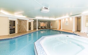 A large indoor swimming pool with a hot tub, stone walls, and a stone shower area. - Grange Hotel (Grange-over-Sands)
