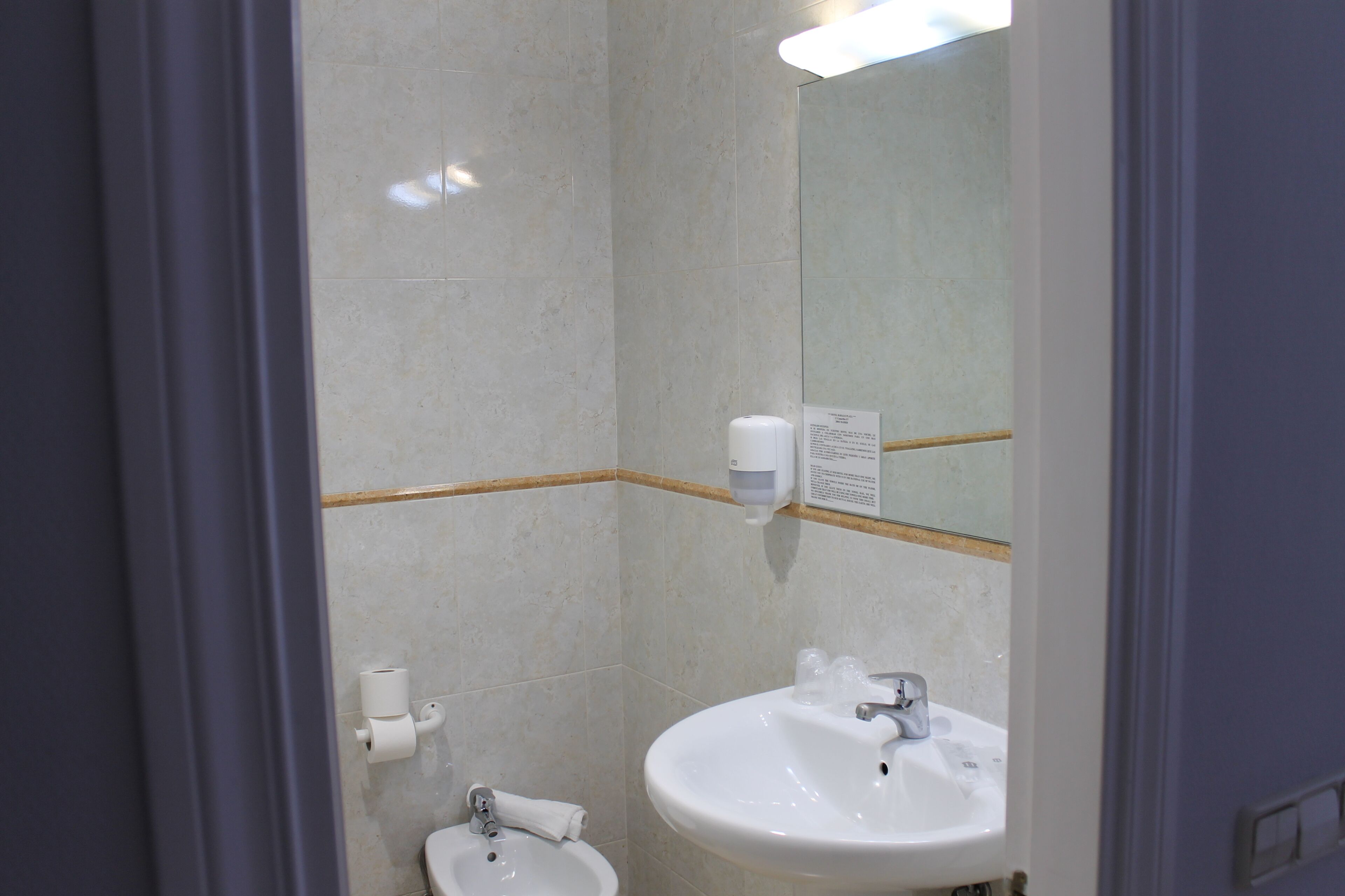 Et badeværelse med toilet, bidet og håndvask.